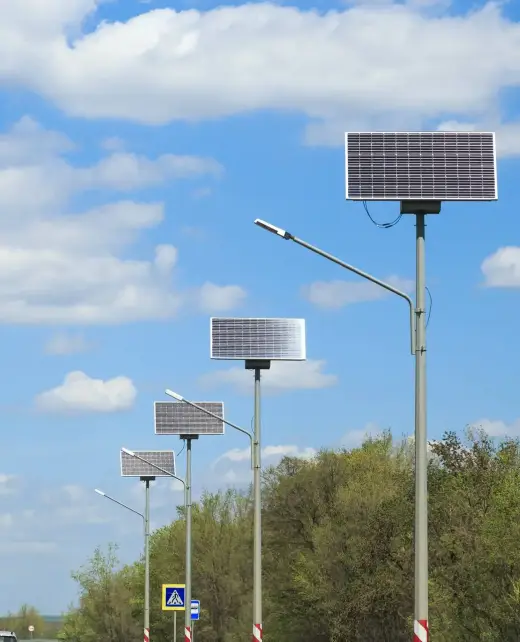 Solar panels along a highway road against a blue sky on a sunny summer day. Eco-friendly cheap alternative electricity.